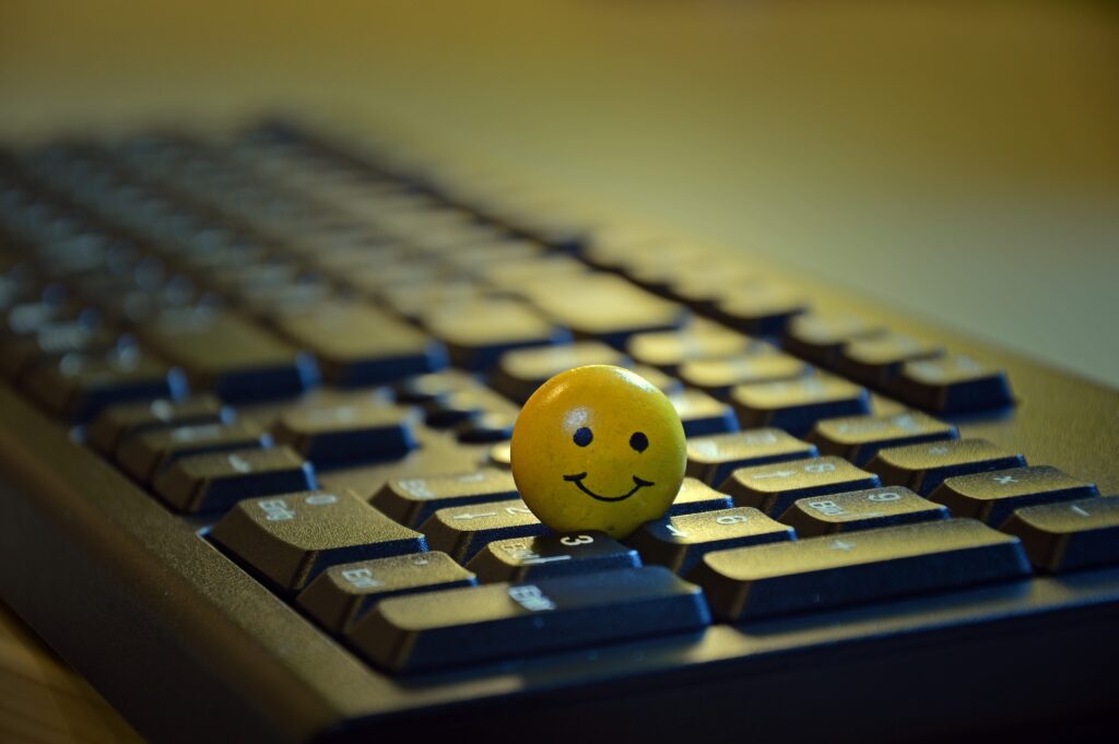 smiley-3901562_1920 Une bille en forme de smiley souriant, posée sur un clavier d'ordinateur vu en contreplongée, symbolisant la simplicité et la fiabilité de la téléconsultation. Le sourire de la bille reflète l'expérience positive et accessible qu'offre la consultation en ligne. Cette image met en avant la facilité d'accès aux services de thérapie en ligne, suggérant que la prise en charge à distance peut être tout aussi efficace, professionnelle et accueillante que la consultation en présentiel, avec une interface simple et agréable.